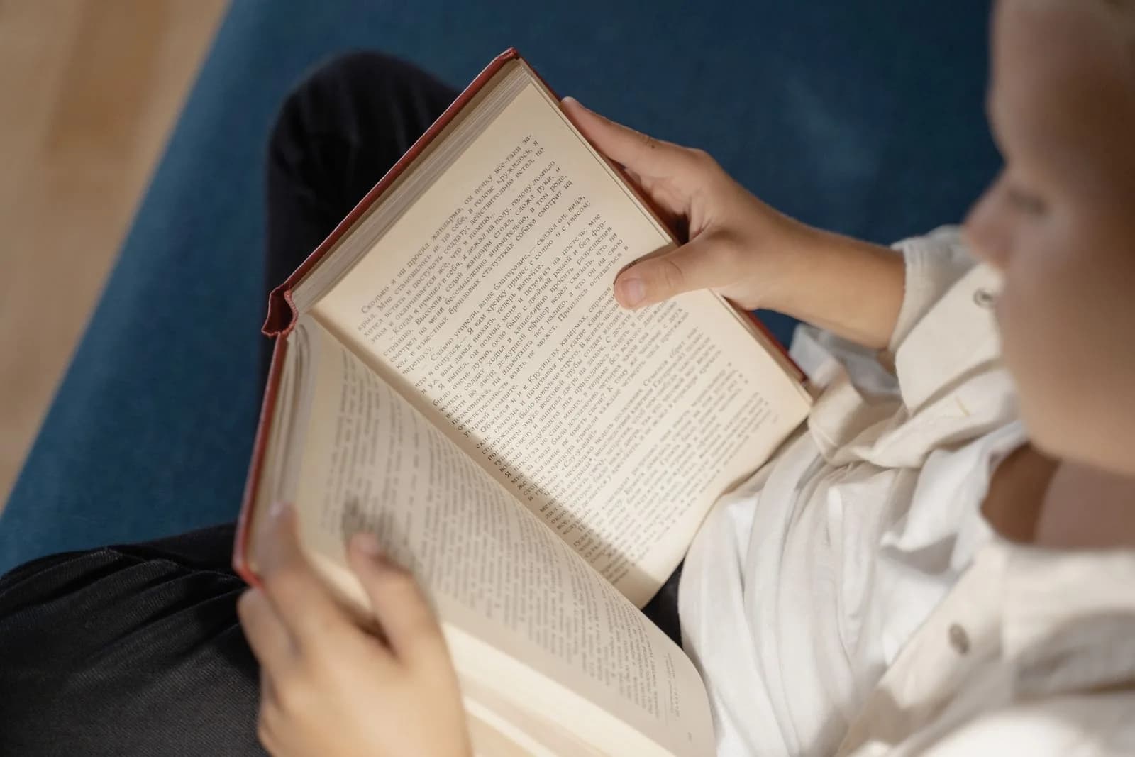 A child holding and reading an open book.