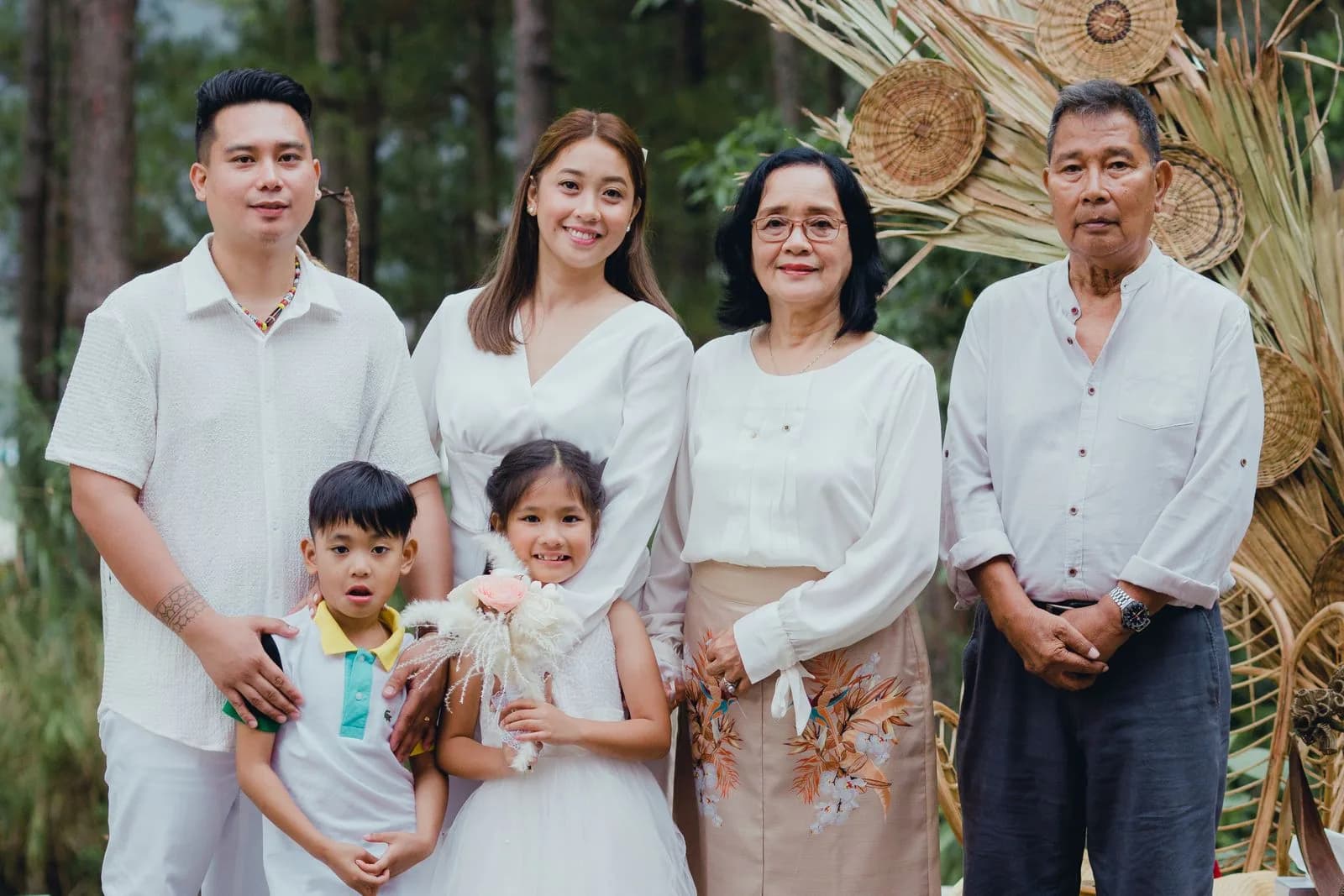 A multigenerational family standing together outdoors.