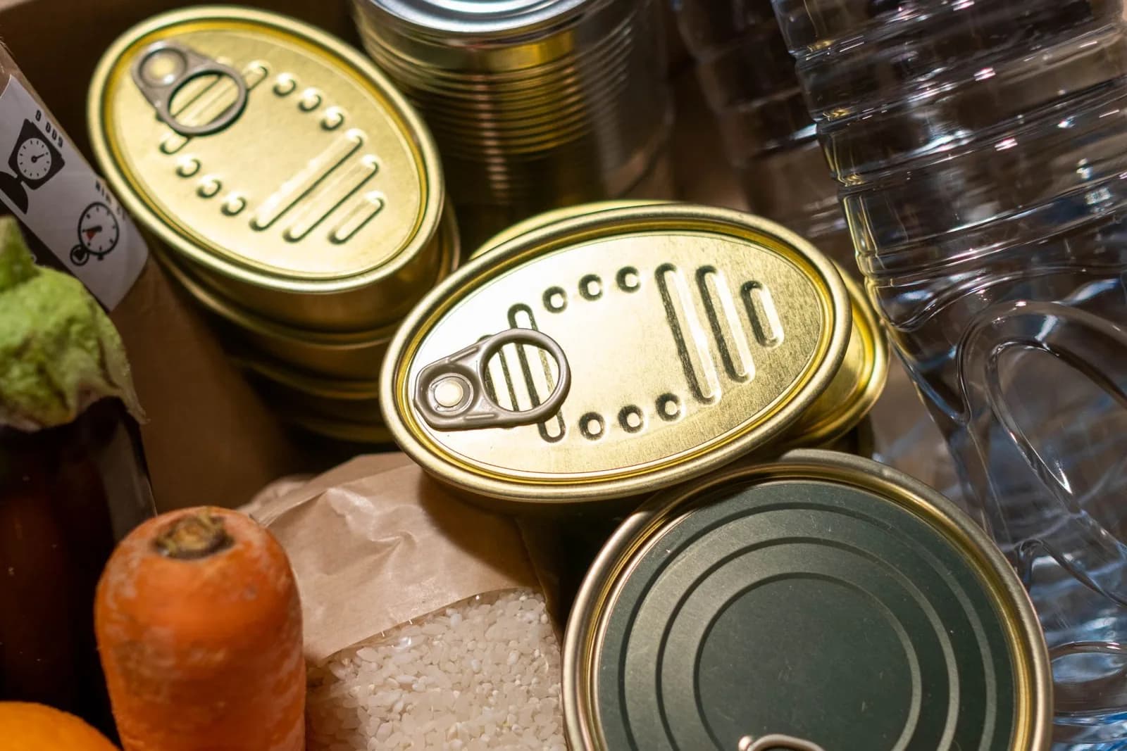 A box filled with canned food, rice, vegetables and other essentials.